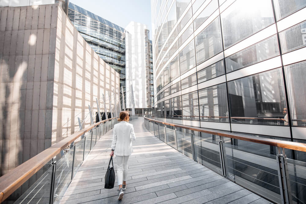 Businesswoman walking in financial district with modern buildings in Paris