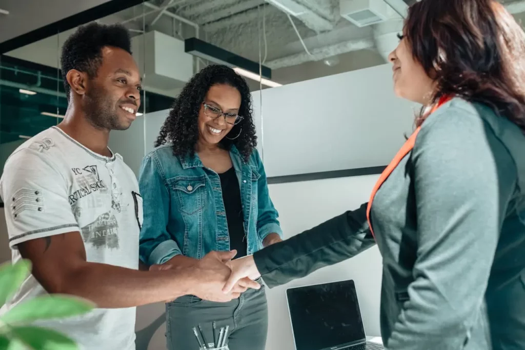 Happy clients introducing their friends to a real estate agent