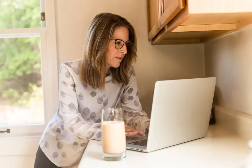 A Realtor planning social media posts on a laptop