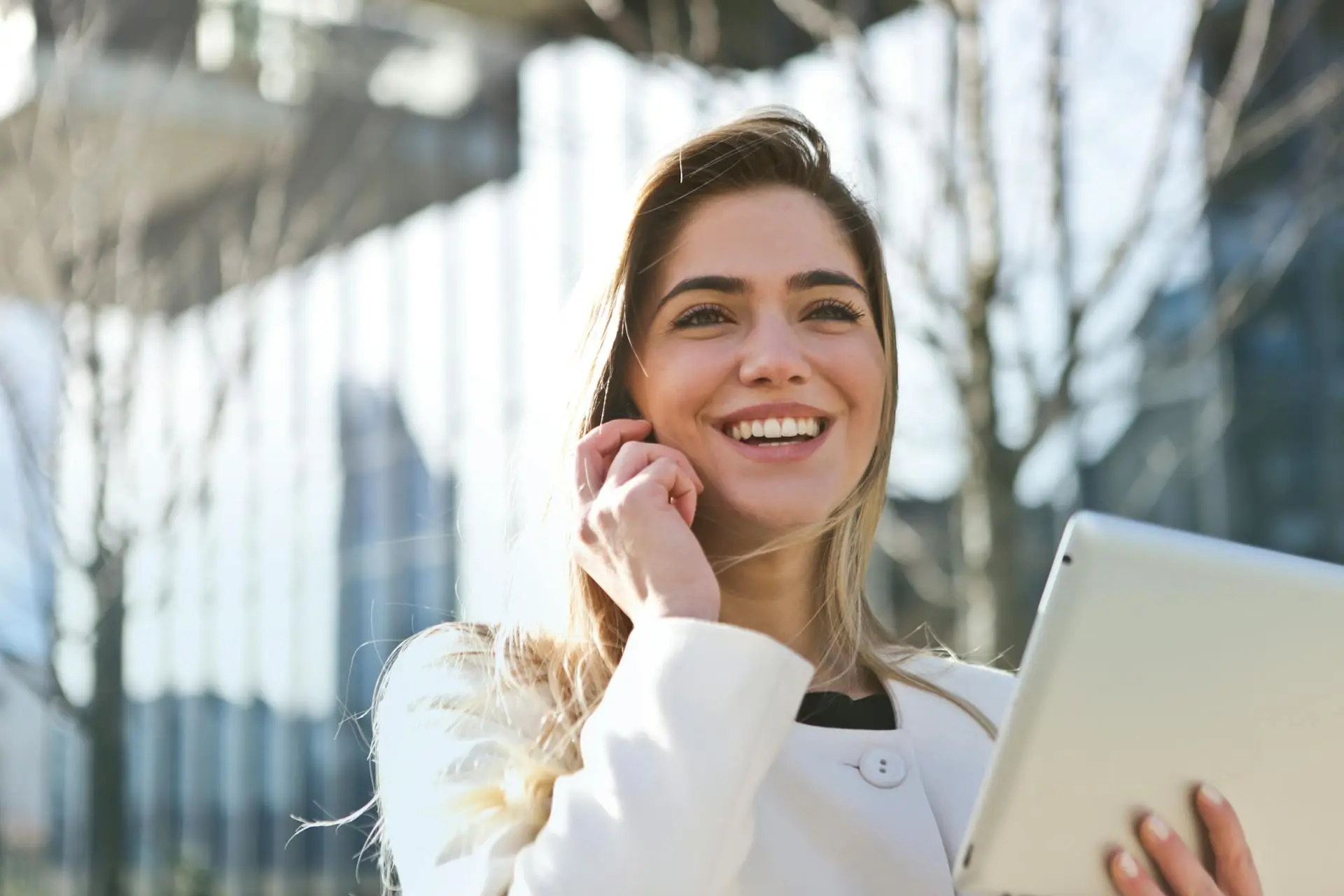 A Realtor sitting at a desk making a phone call while checking notes