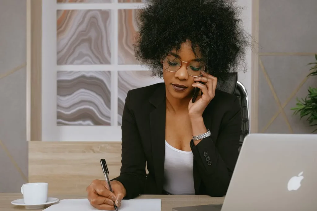 A Realtor speaking on the phone while working on a laptop