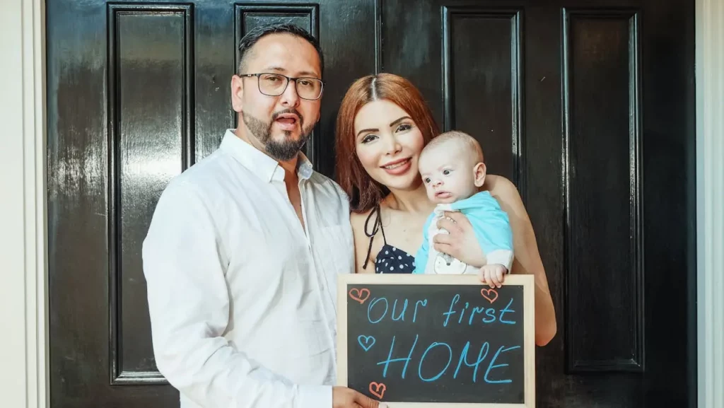 A smiling family holding keys to their new home