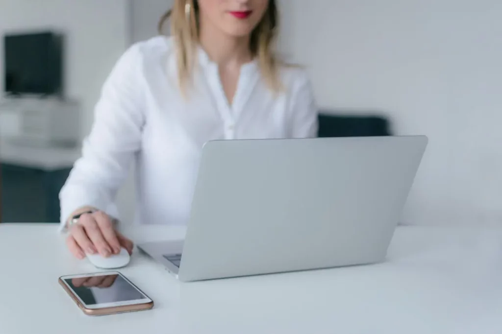 A Realtor checking a list of registered open house attendees on their laptop.