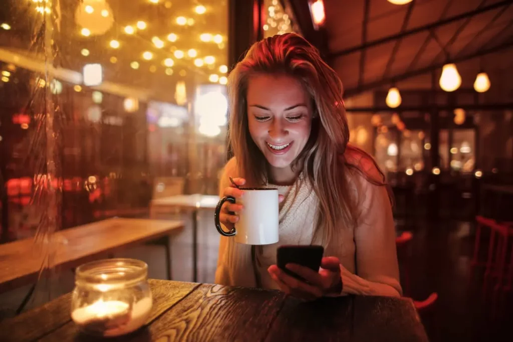 A Realtor setting their availability on their phone while enjoying coffee.