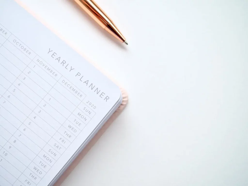 A Realtor with a calendar and planner, scheduling their day.