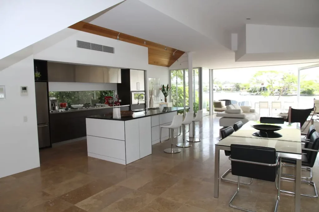 White wooden dining table with six chairs set in a luxury home