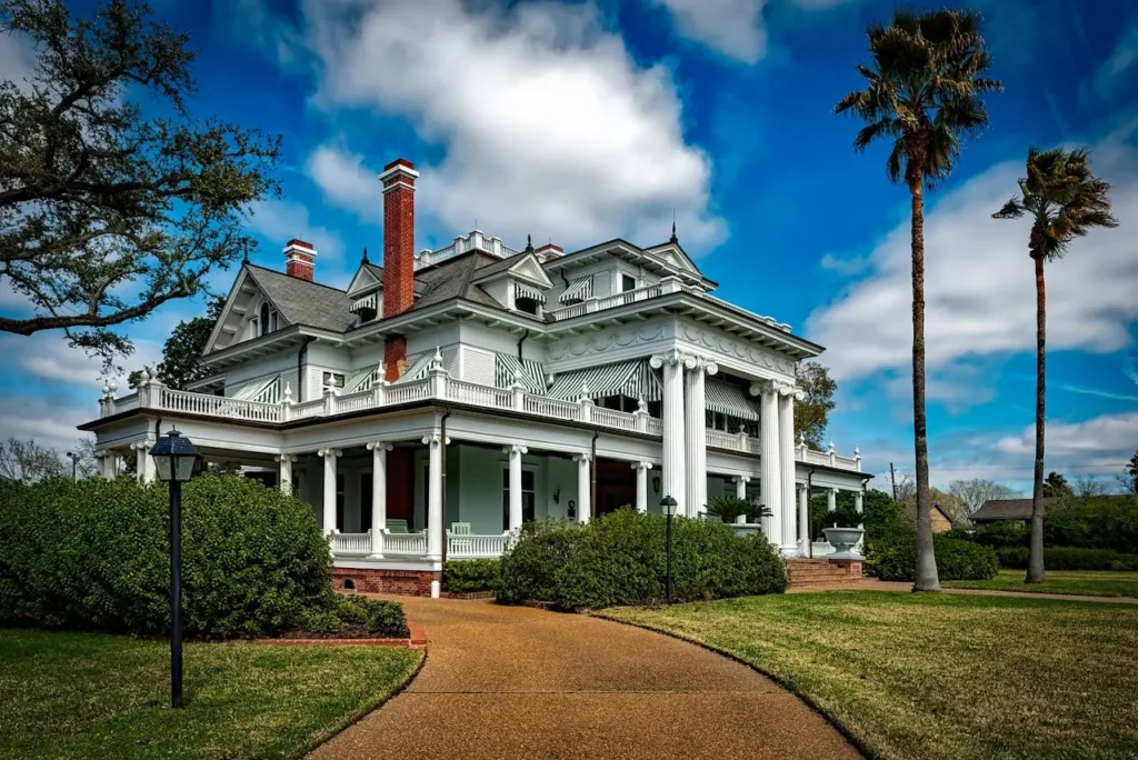 A gated luxury home entrance with lush landscaping.