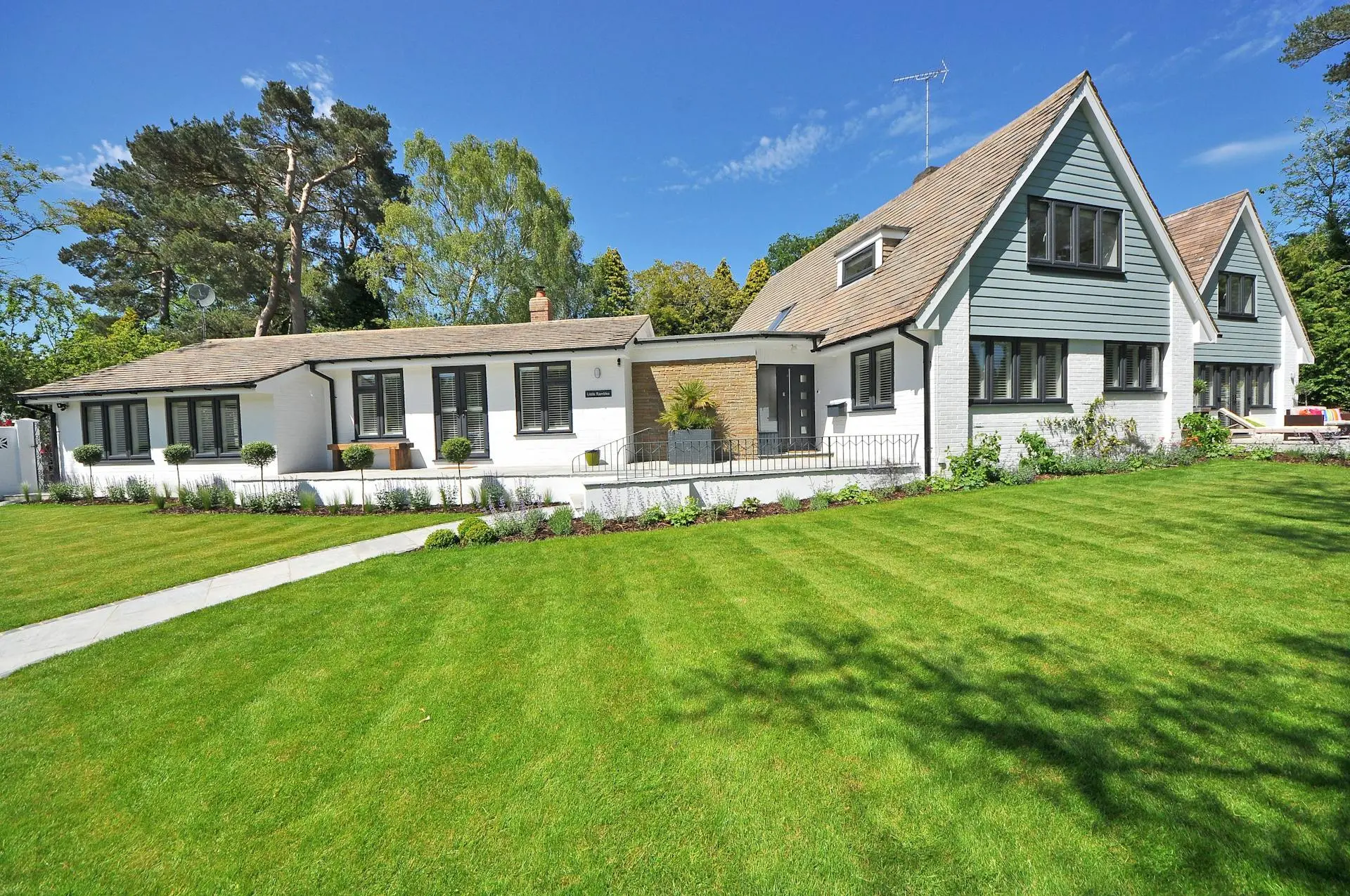 Bright, modern home with flowers blooming in the front yard.